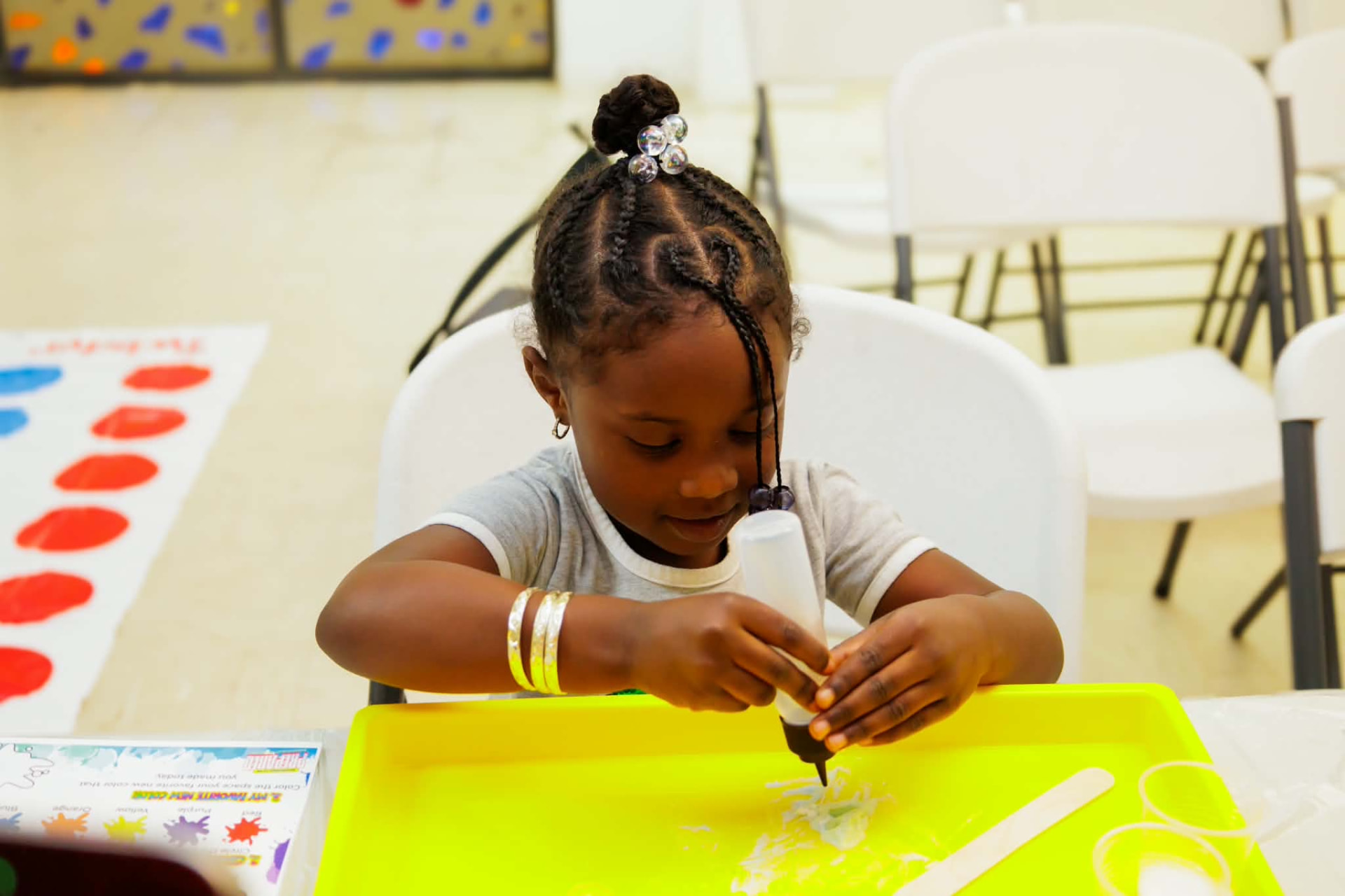 Student carefully squeezing glue onto a tray during a hands-on activity