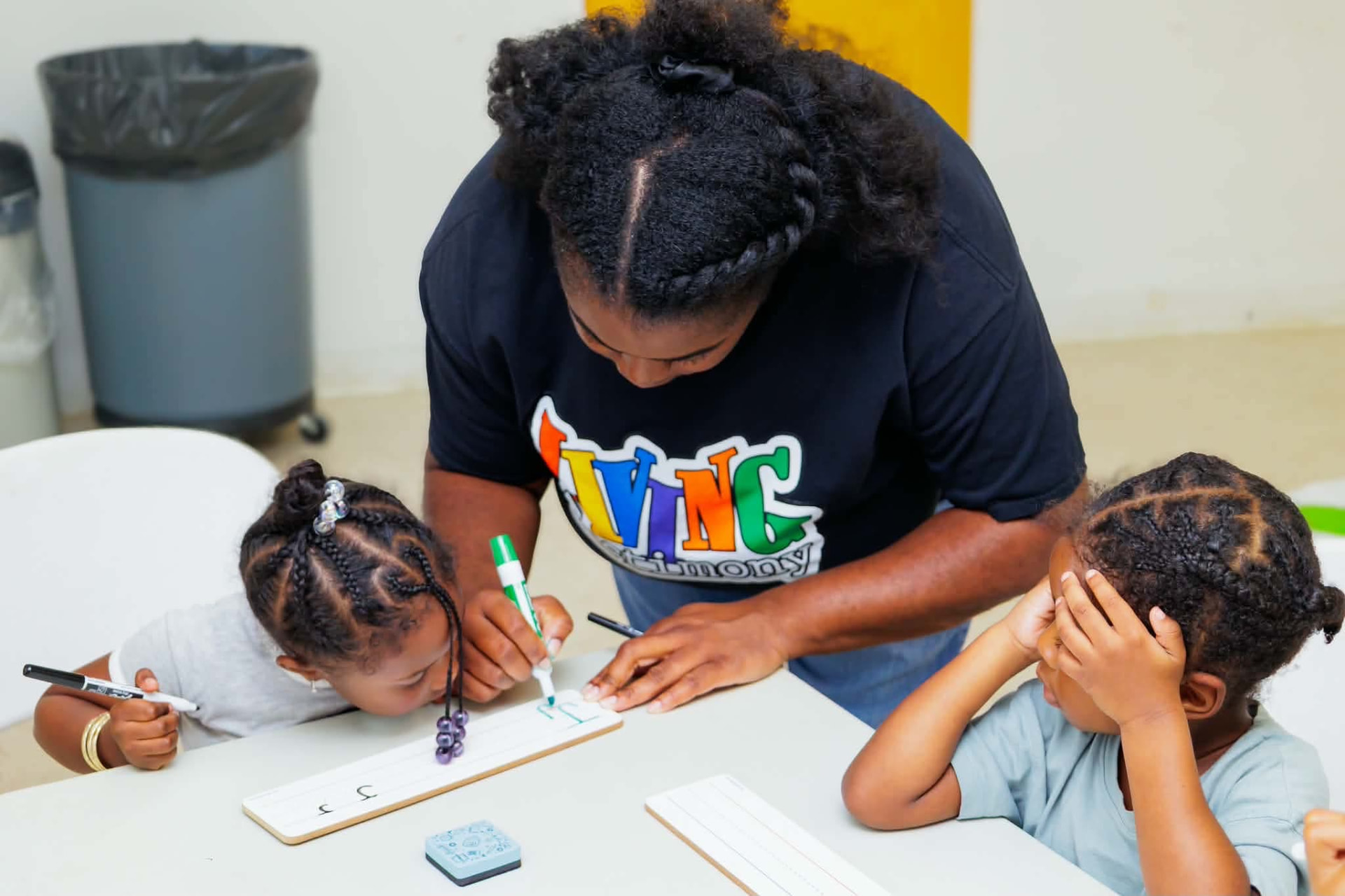 Coach helping a student form letters on a handwriting board